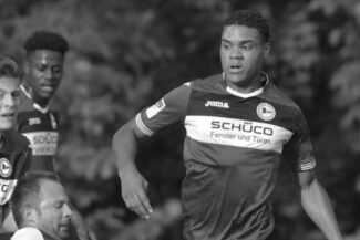 Soccer players competing during a match, focused on the ball.