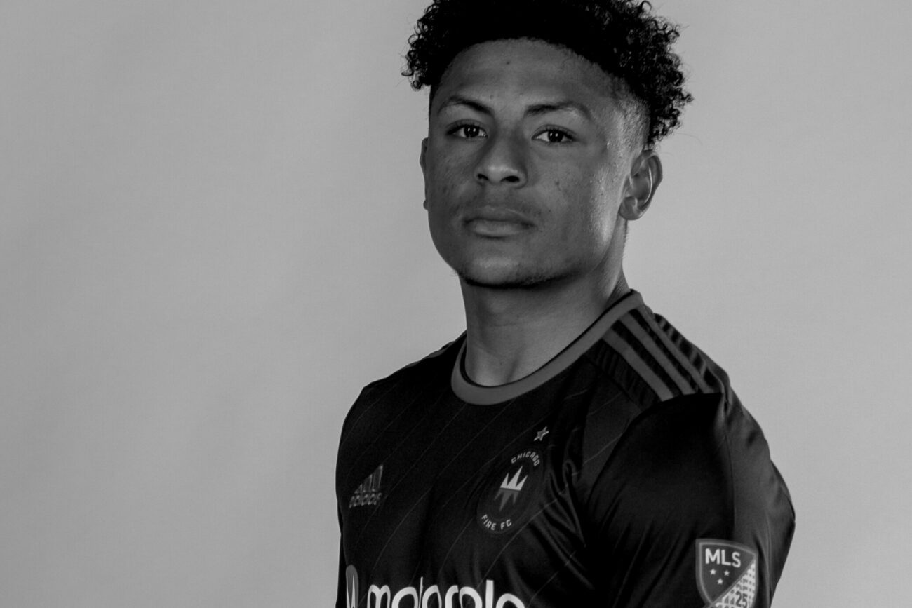 Portrait of a young soccer player in a black jersey with MLS patch.