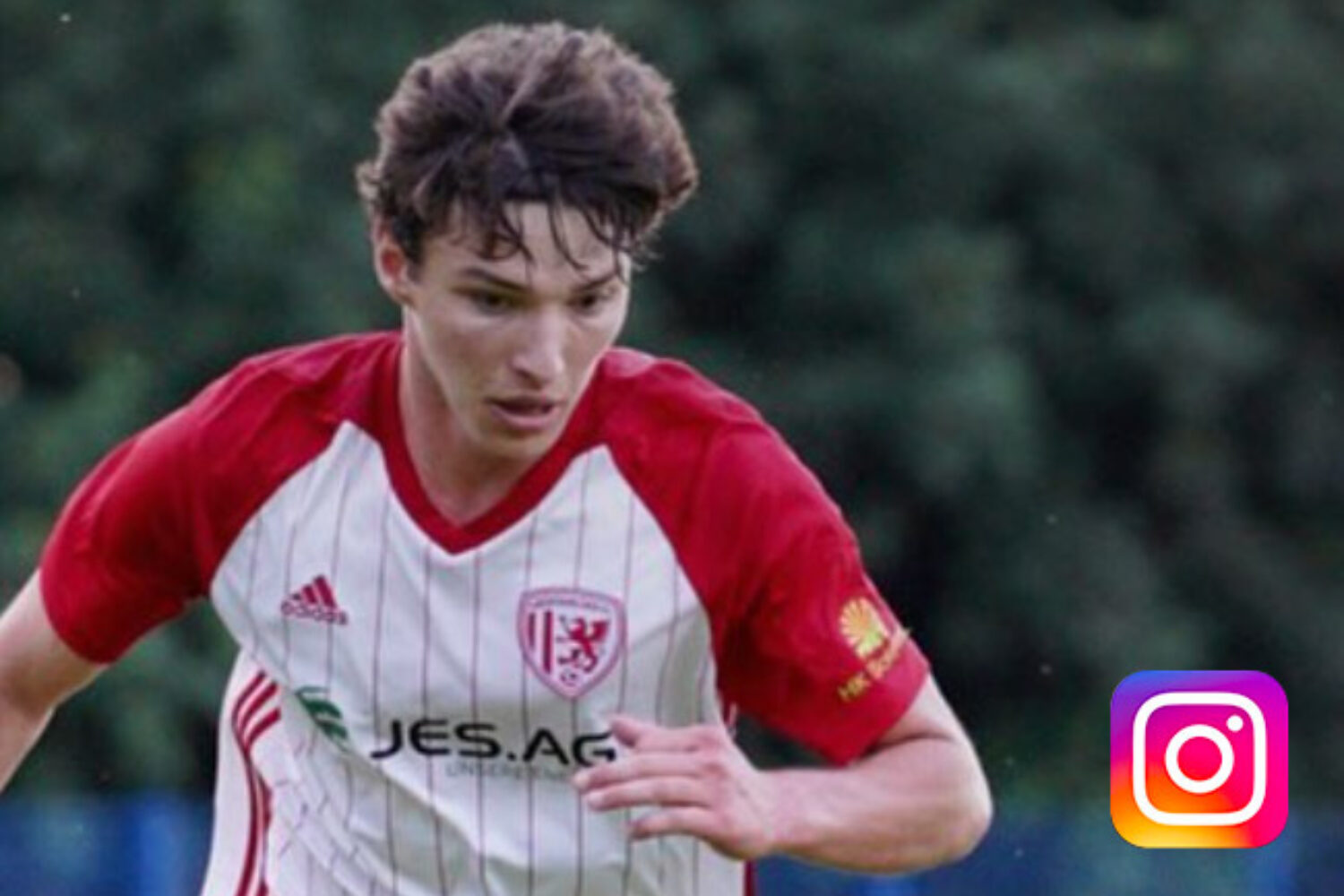 Young soccer player in red and white jersey focused on the game.
