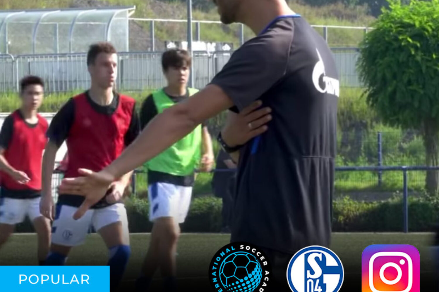 Soccer players training on a field with a coach giving instructions.