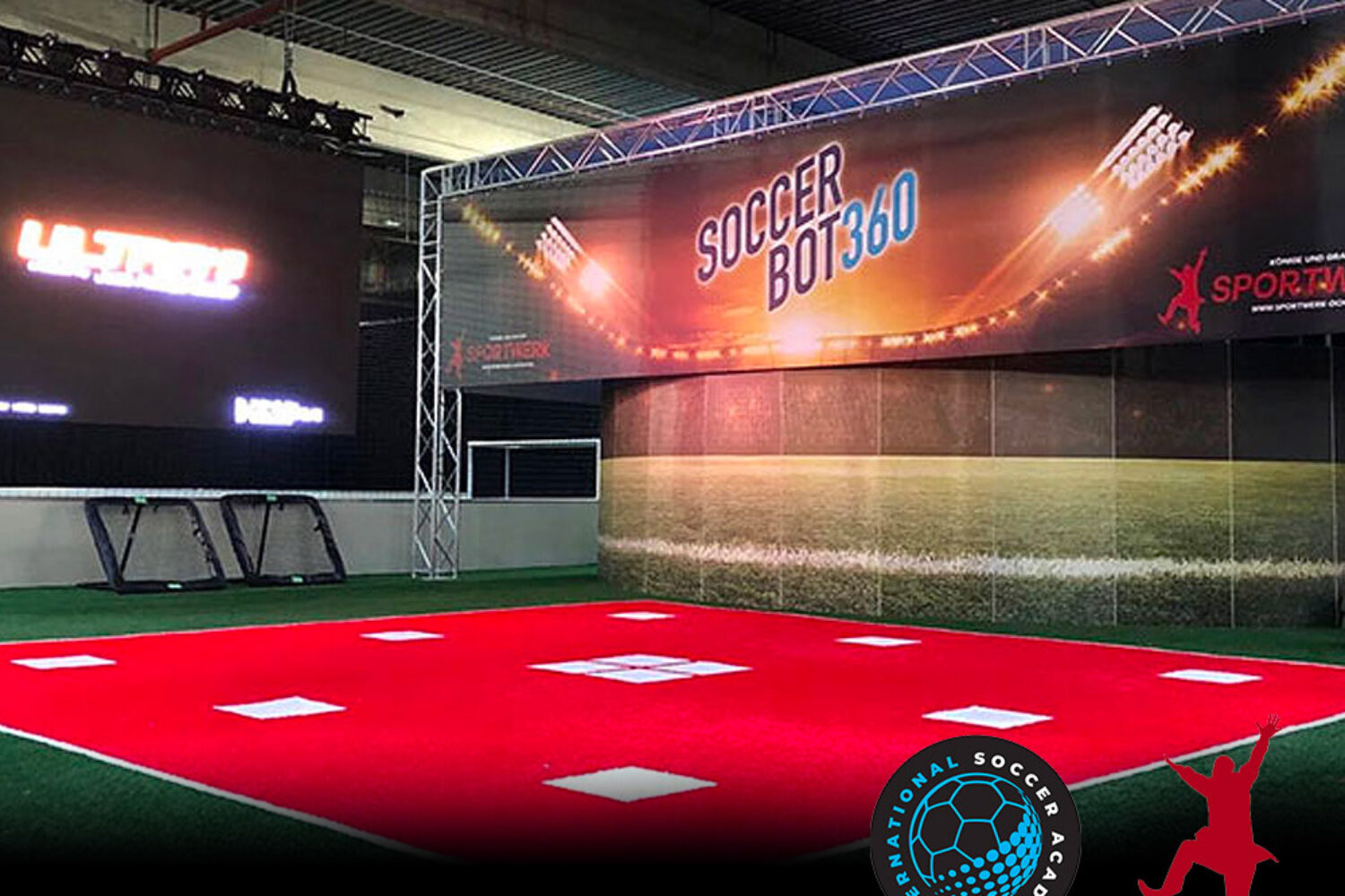 Indoor soccer training setup with red turf and Soccer Bot360 banner.