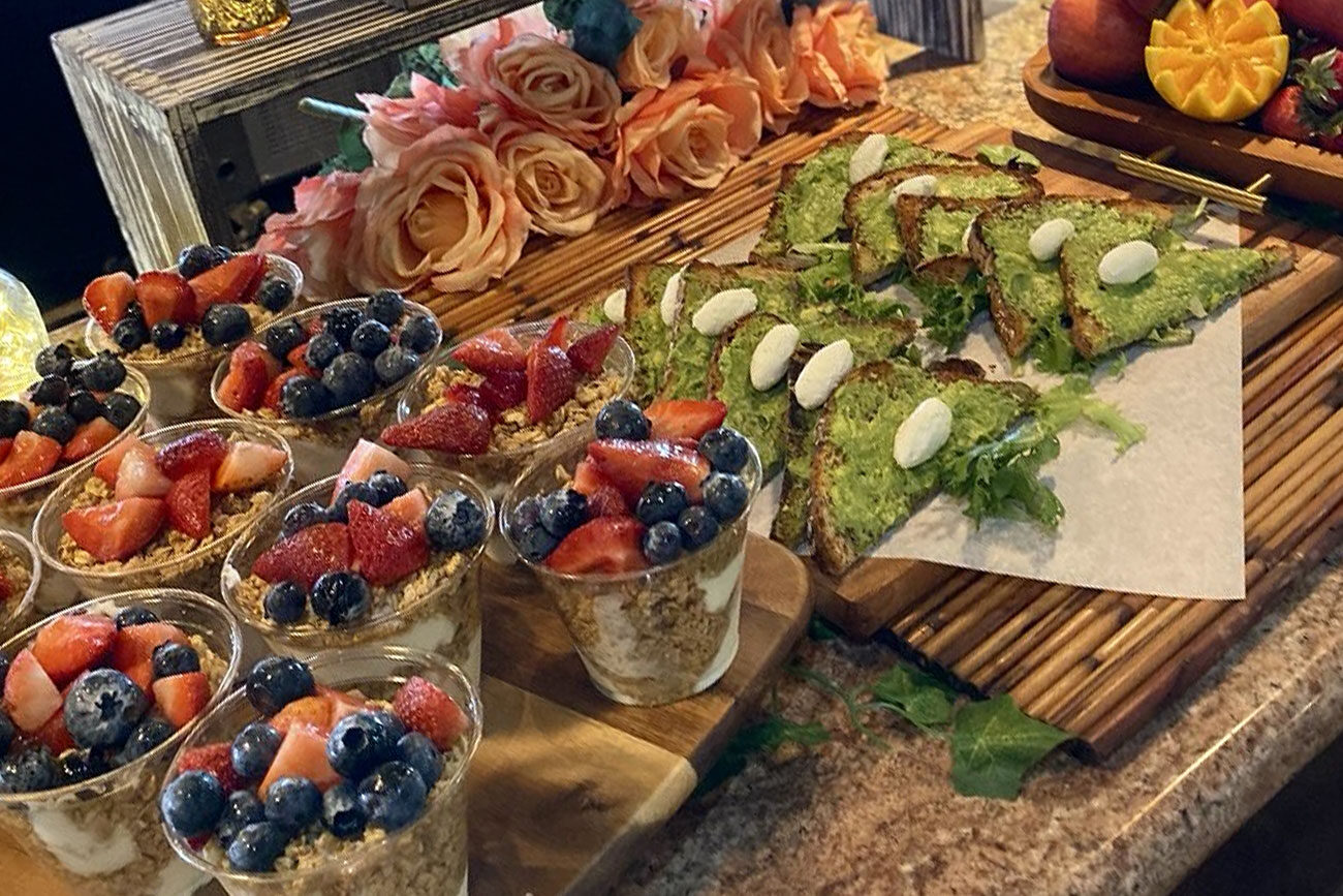 Assorted parfaits with berries and green herb-seasoned flatbreads on display.