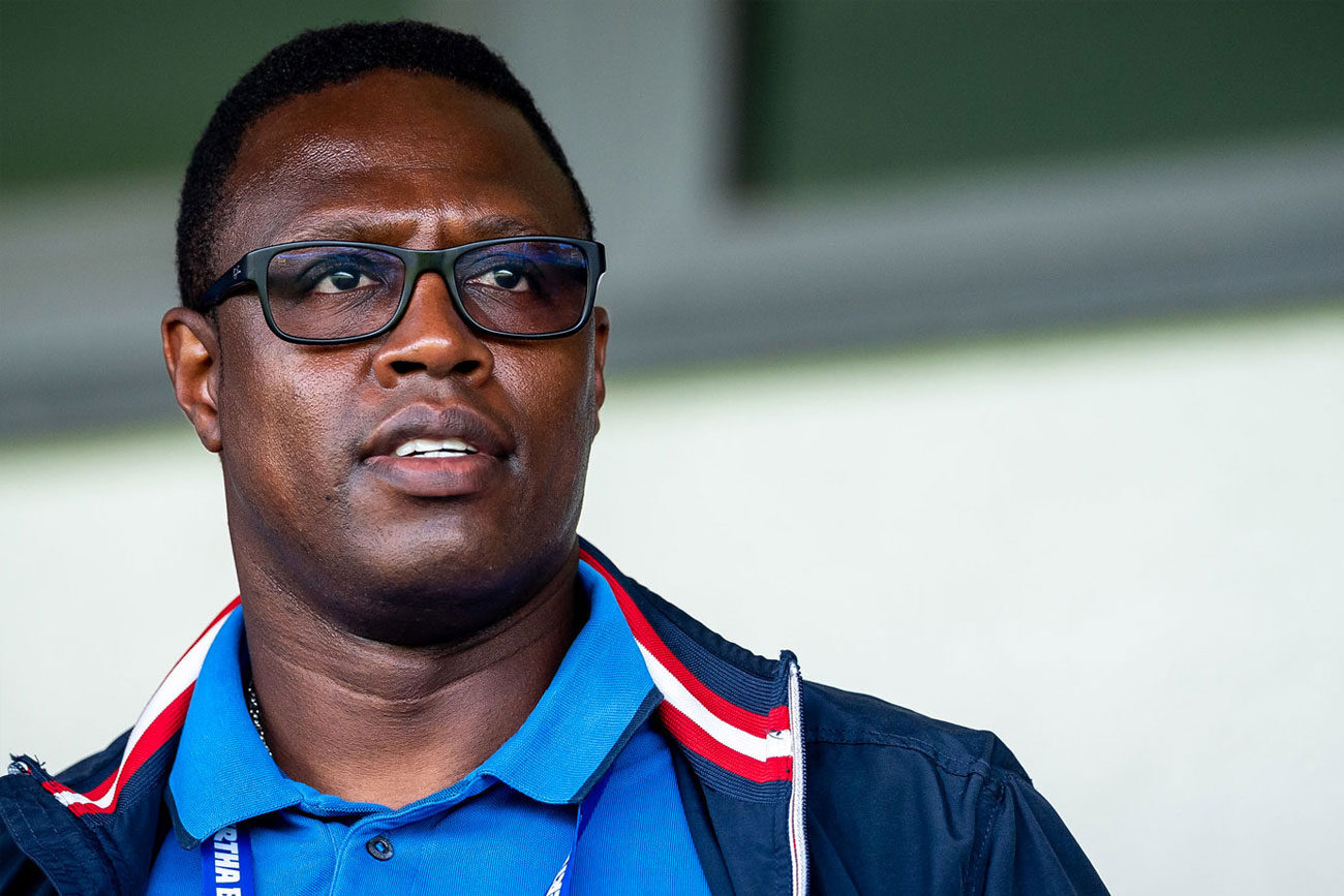 Man wearing glasses and a blue shirt with a jacket.