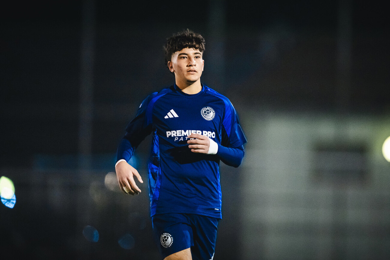 Young soccer player in blue uniform on the field during a game.
